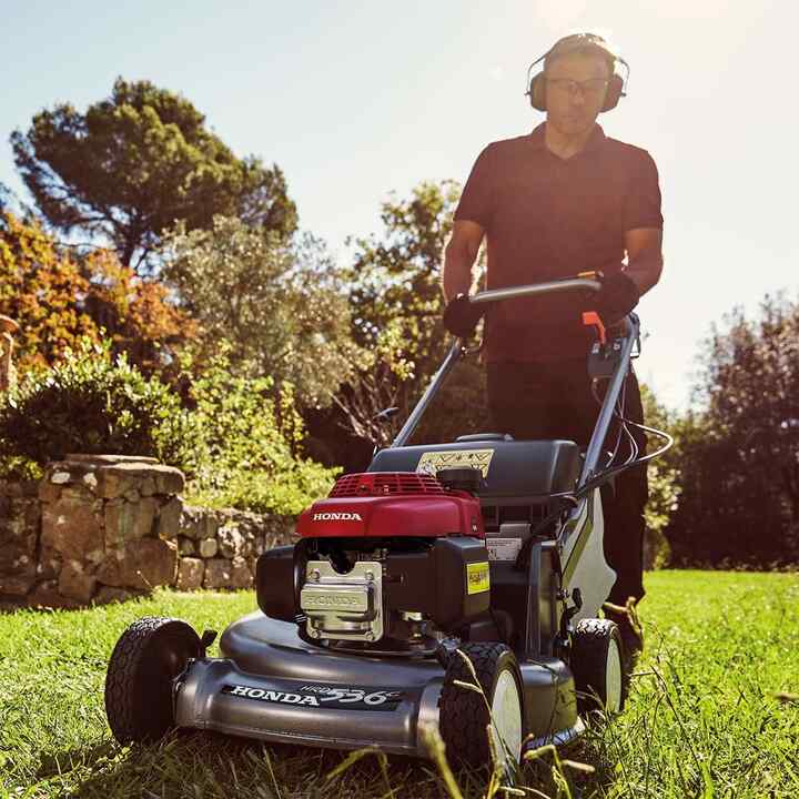 Man in tuinomgeving maait gras met Honda HRD grasmaaier.