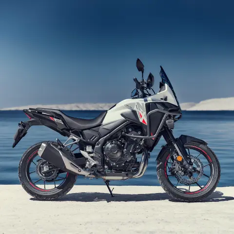 Honda NX500 statisch zijaanzicht tegen kustlijn